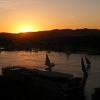 Feluccas and cruise ships on the Nile in Aswan at sunset.