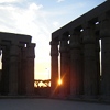 The sun setting through columns at Luxor Temple.